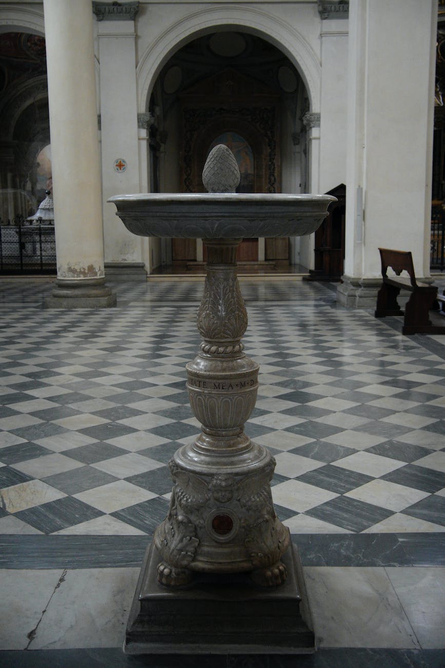 a white and black marble pedestal with a bird bath